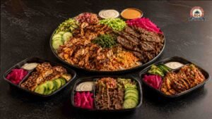 Large halal platter with grilled meats, rice, vegetables and three prepared meal containers.